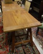 An Eastern hardwood rectangular topped table with cleated end supports, raised on folding trestles,