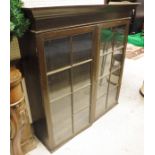 A stained oak wall-hanging bookcase with ogee moulded pediment above two astragal glazed doors