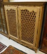 A Continental pine food cupboard with moulded cornice over a carved frieze and pair of lattice work