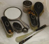 A collection of George V silver mounted and tortoiseshell dressing table accoutrements to include