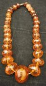 A carved amber graduated faceted bead necklace CONDITION REPORTS Total weight is