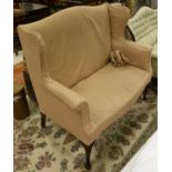 An early 20th Century wing back two seat sofa in pale pink self patterned upholstery,