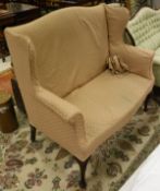 An early 20th Century wing back two seat sofa in pale pink self patterned upholstery,