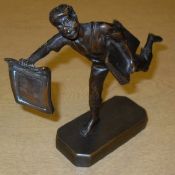 A bronze figure of a newspaper boy holding aloft a silver plaque inscribed "Stroud May 21st 1931"