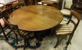 A 19th Century walnut circular table, raised on four carved and turned supports to brass castors,