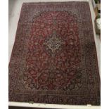 A Kashan carpet, the stepped central medallion with blue, cream and black ground foliate decoration,