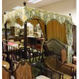 A mahogany framed four poster bed on four turned supports with green and yellow floral decorated