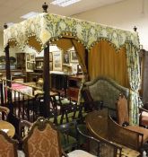 A mahogany framed four poster bed on four turned supports with green and yellow floral decorated