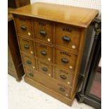 An oak chest of drawers with applied moulded edge above ten assorted drawers with pull lug handles,