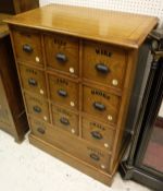 An oak chest of drawers with applied moulded edge above ten assorted drawers with pull lug handles,