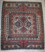 A Caucasian rug, the central panel set with repeating geometric design on a fawn ground,