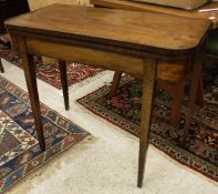 A late George III mahogany fold-over card table on square section tapering supports