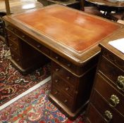 A 19th Century mahogany partner's desk with a red leather tooled and gilded inset top,