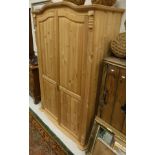 A 20th Century pine two door wardrobe with applied mouldings over the fluted pilasters