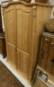 A 20th Century pine two door wardrobe with applied mouldings over the fluted pilasters