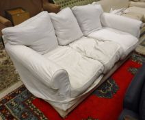 A circa 1900 two seat sofa in plain white loose covers,