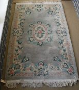 A Chinese superwash rug, the central panel set with floral decorated medallion on a sage ground,