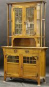 A circa 1900 oak display cabinet in the Art Nouveau taste with embossed copper fittings,
