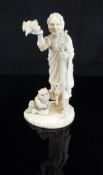 A Japanese Meiji Period carved ivory okimono as a figure with staff in one hand,