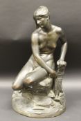 A bronze patinated plaster figure of a nude seated upon a rock,
