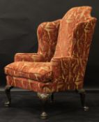 An upholstered wing back scroll arm chair in the early Georgian manner,