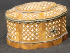 A 19th Century French rosewood and ivory inlaid casket of shaped oval form with applied gilt brass