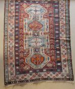 A Kasak rug, the central panel set with four repeating medallions on an aqua blue ground,