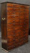 A Victorian painted/stained pine mahogany effect bank of 24 drawers with turned wooden handles,