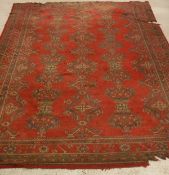A Turkamen rug, the centre field with conjoined medallions in three columns on a red ground,