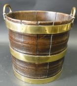 A late George III Irish mahogany coopered brass bound peat bucket with two fixed loop handles,