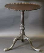 A circa 1900 mahogany snap top tea table, the circular top with pie crust rim,