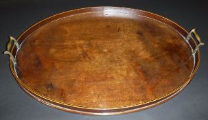 A Regency mahogany oval drinks tray with brass handles, the rim with ebony and satin wood stringing,