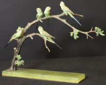 A cold-painted bronze figure group as five budgerigars upon a branch on a green onyx base,