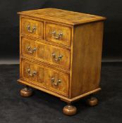 An oyster walnut and inlaid chest of two short over two long drawers to turned feet, 66.