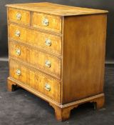 An oyster walnut and mahogany banded square chest of two short over three long graduated drawers in