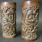 A pair of 19th Century Chinese carved bamboo brush pots decorated with scholars conversing in and
