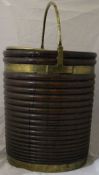 An 18th Century ribbed walnut and brass bound peat bucket of typical form with brass swing handle,