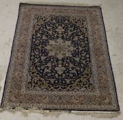 A 20th Century silk Persian rug with stylised central star motif on a blue ground with scrolling