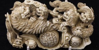 A Japanese Meiji Period carved ivory figure group as a lioness and cubs with balls amongst clouds,