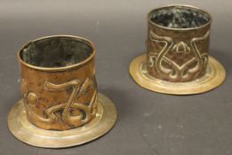 A pair of circa 1900 Art Nouveau embossed copper coasters in a cylindrical body with stylised