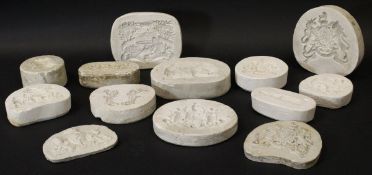 A collection of eleven various plaster pottery moulds including various Coats of Arms "Alls well