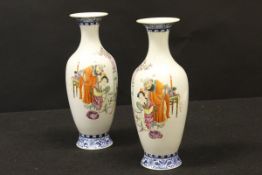 A pair of Chinese polychrome decorated vases, the main bodies decorated with figures in an interior,