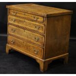 A walnut and feather banded bachelor's chest in the 18th Century manner with fold-over top above