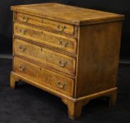 A walnut and feather banded bachelor's chest in the 18th Century manner with fold-over top above