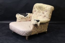 A 19th Century armchair in the Howard manner with mahogany turned front legs to brown china castors