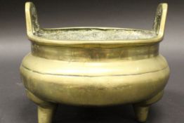 A Chinese bronze censer of typical bellied form with open work handles,