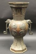 A Chinese chocolate patinated bronze vase, the octagonal tapered rim with stylised leaf decoration,