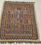 A Kelim rug, the blue, light blue, red and oatmeal decoration on a red ground,