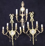 A pair of gilt brass four branch wall sconces in the Regency taste with ribbon tied support holding