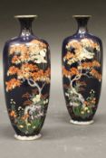 A pair of Japanese Meiji period cloisonné vases decorated with birds amongst maple and blossom